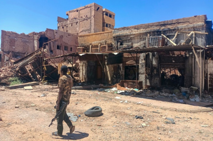 A fighter loyal to Sudan's army patrols a market area in the capital Khartoum