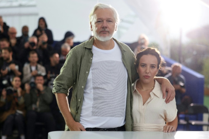 Assange wearing a t-shirt with the names of killed Gaza children, with his wife Stella - Sameer Al-Doumy (AFP)