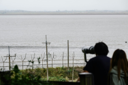Telescopes are the only way refugees on South Korea's Gyodong Island can see the place they once called home - ANTHONY WALLACE (AFP)